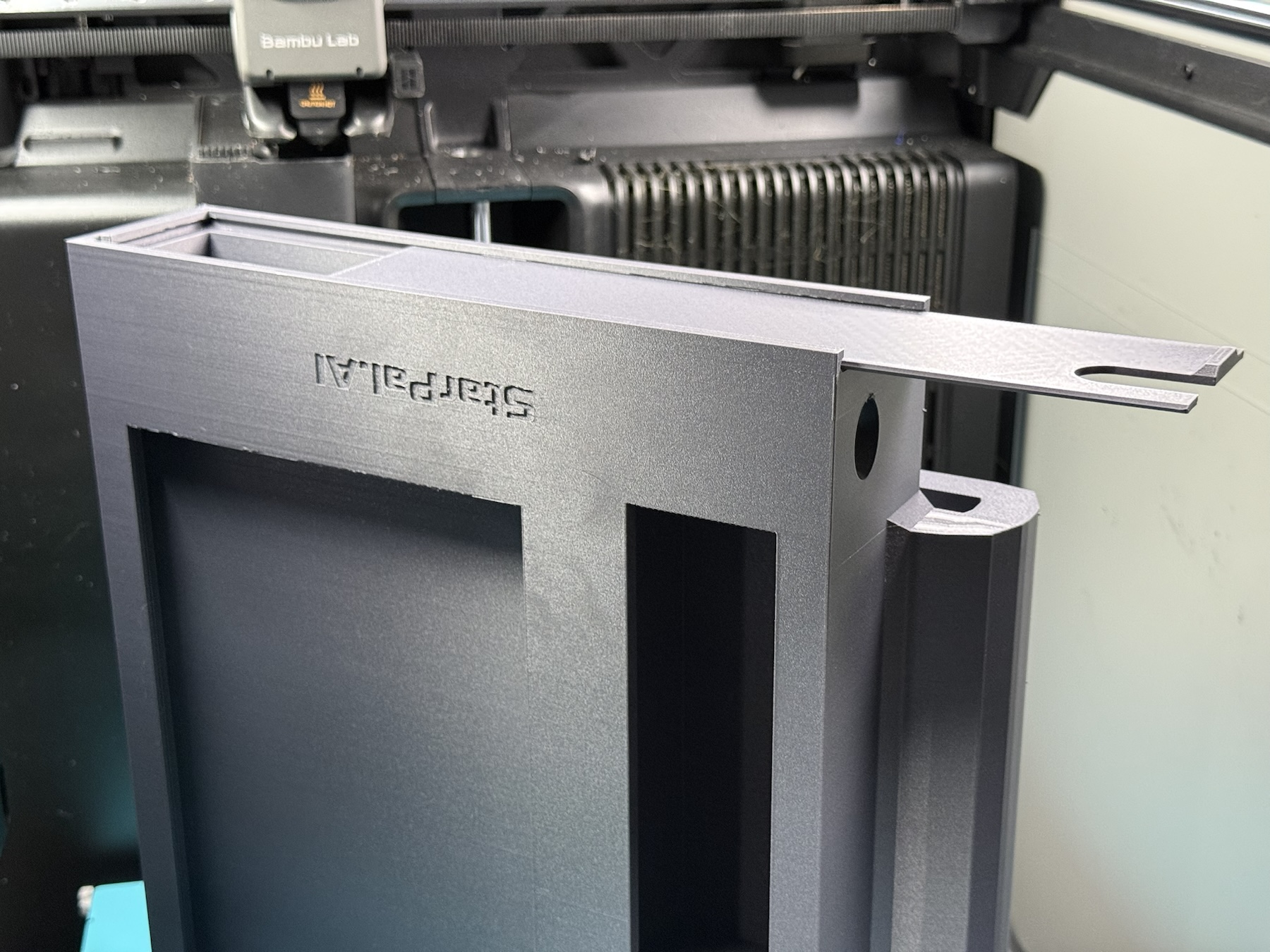 Side view of a later black enclosure print with an extended mounting feature