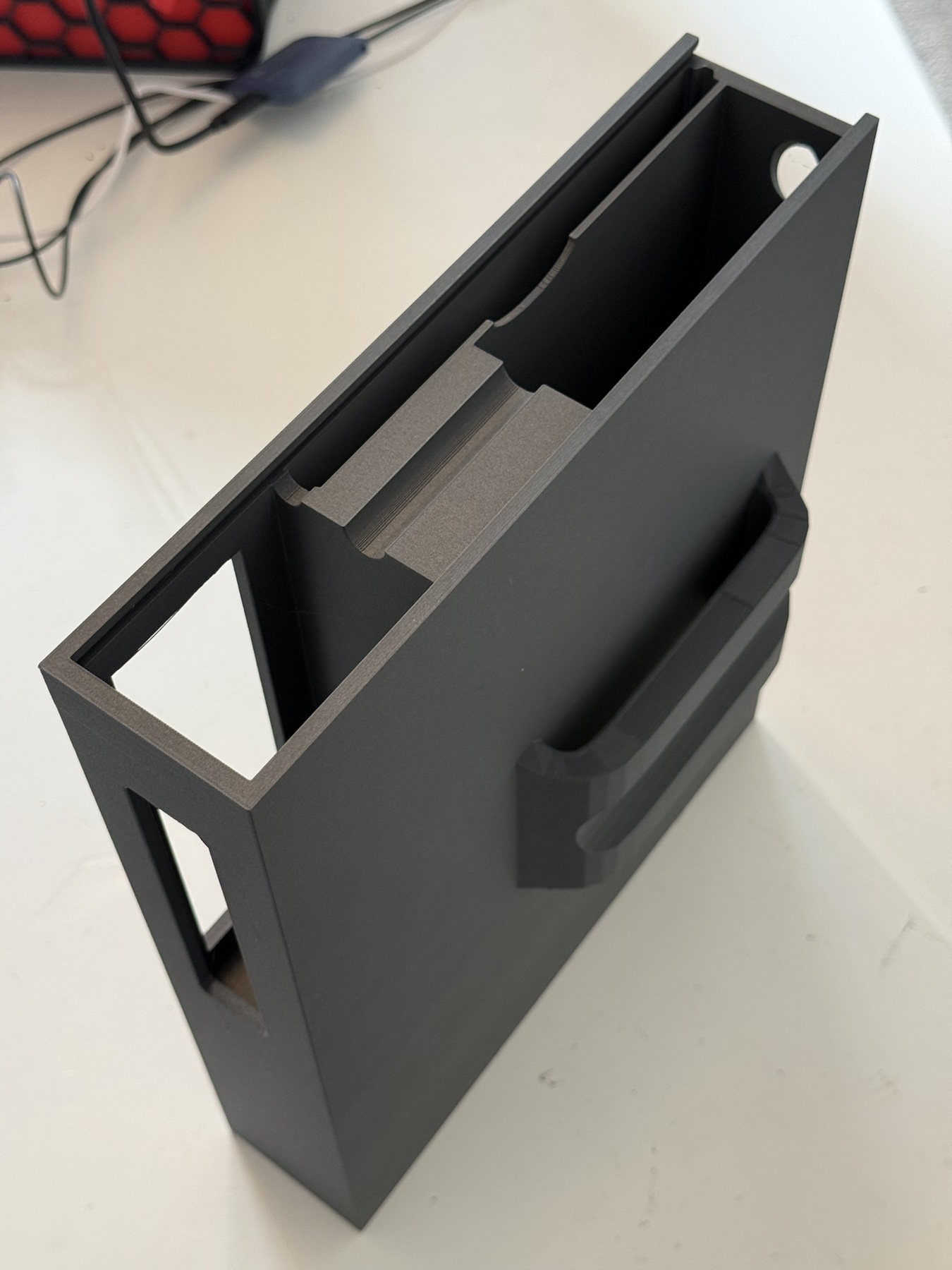 Black printed case showing its internal channel, side aperture and external mounting feature
